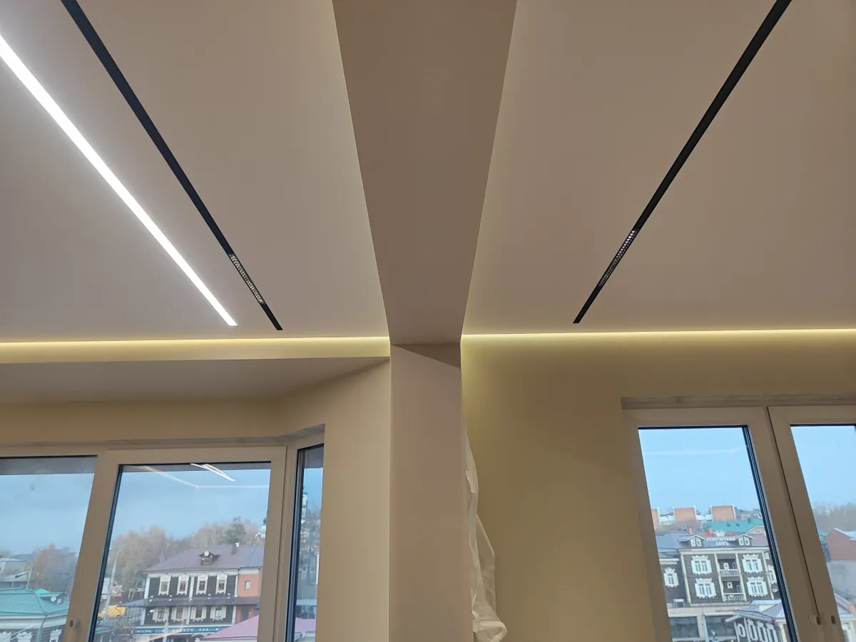 Трековые светильники на белом натяжном потолке в современном интерьере